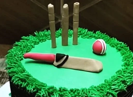 Close-up of handcrafted cricket decorations on birthday cake